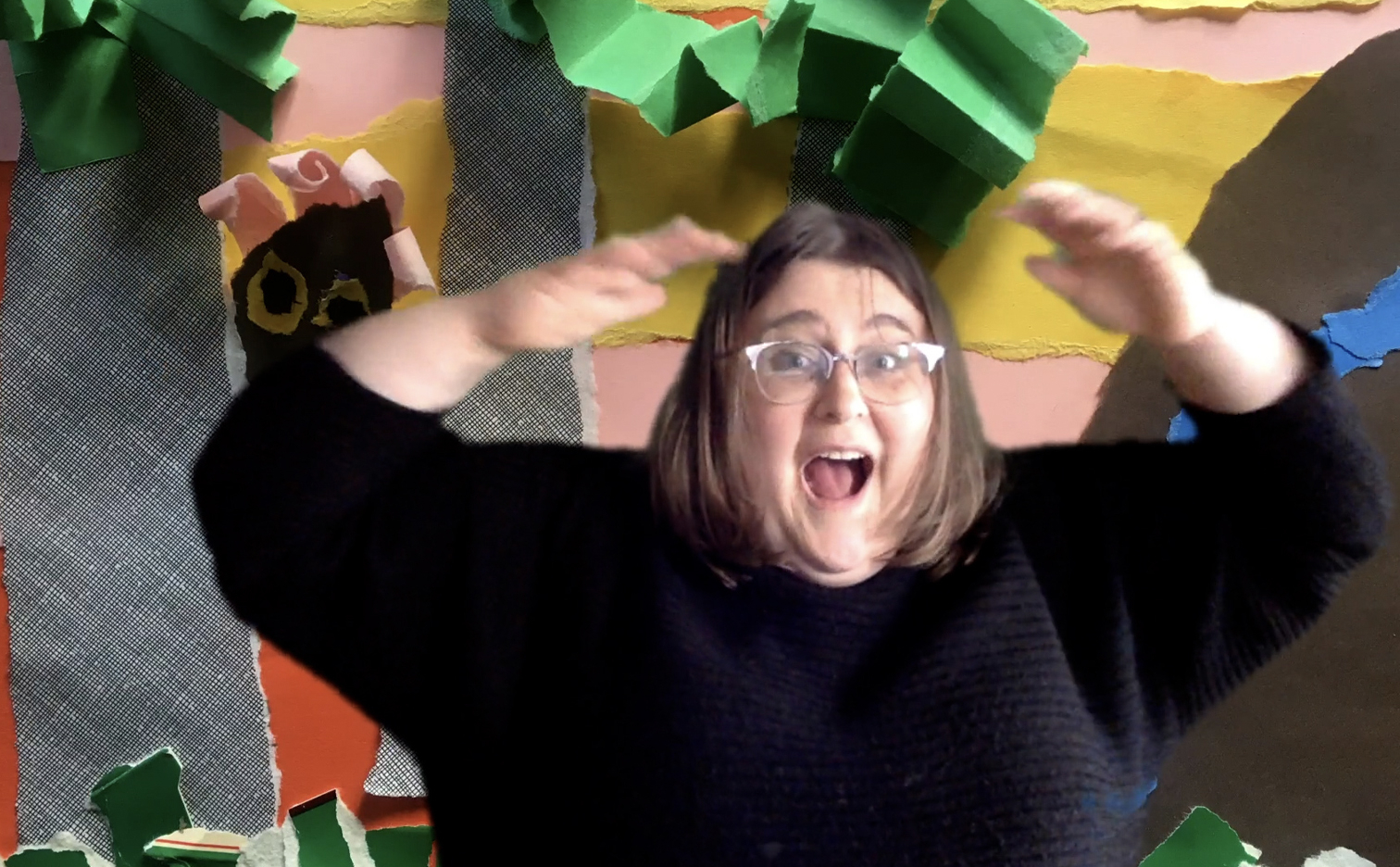 Teaching artist Susanna Brock looking surprised and excited by making her zoom background a picture of a torn paper collage setting.