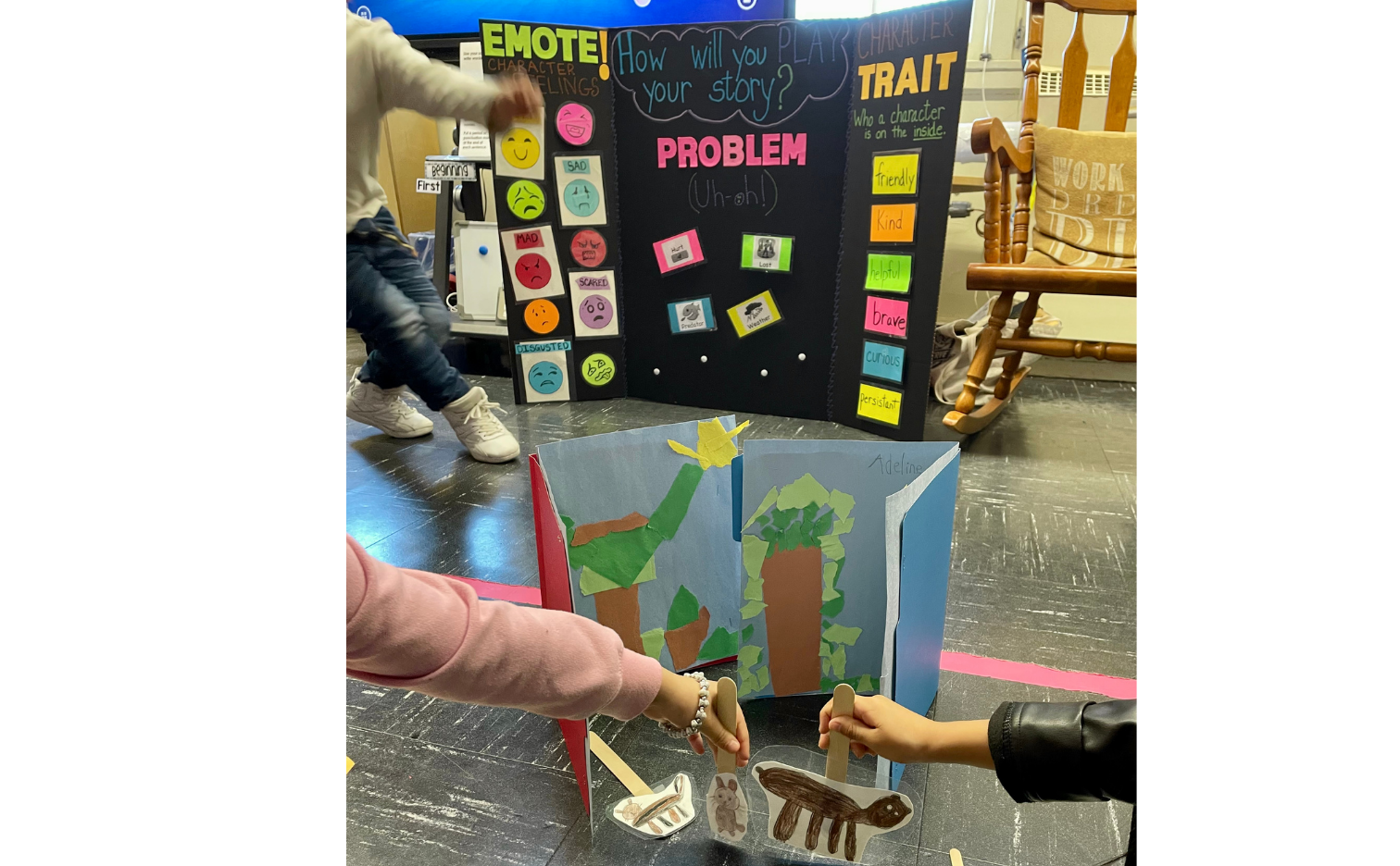 students play with small animal puppets in front of a posterboard that says story problem